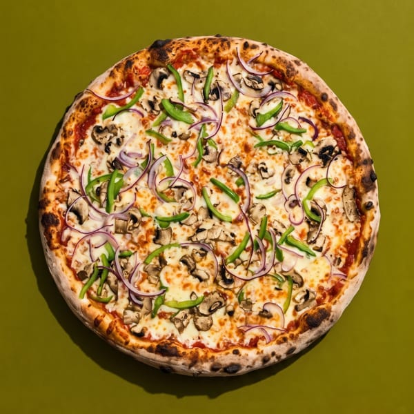 A whole pizza with mushrooms, green peppers, and red onions on a green background.